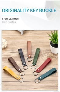 Flat lay of colorful split leather keychains with metal rivets on a wooden surface