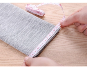 Detailed view of grey fabric texture with tape measure showing sleeve size scale