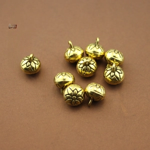 Close-up of vintage golden flower bell charms for DIY jewelry and hair accessory crafts