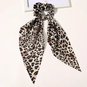 Detailed view of leopard print satin scrunchie with long ribbons on white background