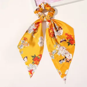 Detail of yellow floral satin hair scrunchie with long ribbon and butterfly print