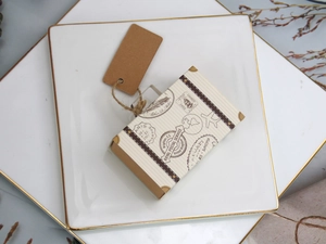 Vintage mini suitcase favor boxes with twine and kraft tags on elegant ceramic plates