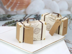 Detail of mini travel suitcase favor boxes with vintage postal prints and kraft paper tags