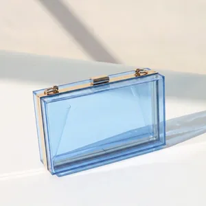 Macro detail of transparent blue acrylic evening clutch bag with gold metal frame