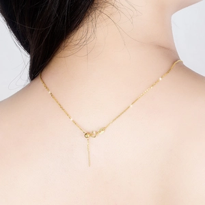 Detail of adjustable gold O-chain necklace with spring clasp and extension chain on neck