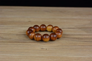 Macro shot of polished 12-piece cedar wood prayer beads with natural cloud grain patterns