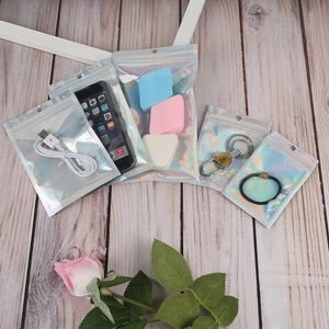 Various sizes of holographic laser resealable bags showing storage for tech and beauty items