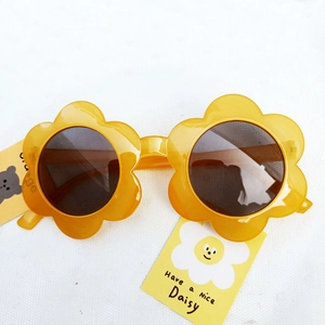 Close-up of yellow flower frame sunglasses with dark lenses and daisy themed tag