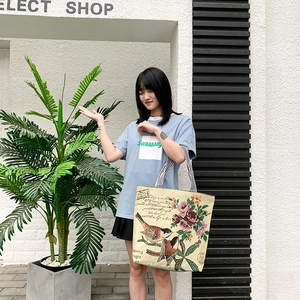 Asian model carrying a large canvas tote with vintage floral print and striped straps