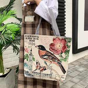Detail of beige canvas tote bag with vintage bird and floral prints and striped handles