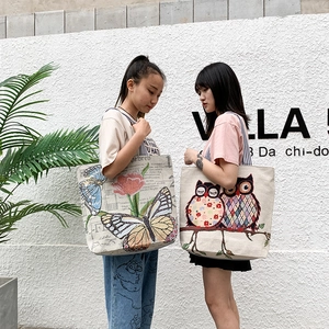 Close-up of canvas tote bags with butterfly and artistic owl patterns in high detail