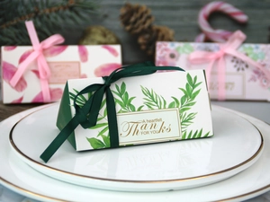 Dettaglio delle scatole regalo triangolari con stampe floreali e nastri eleganti