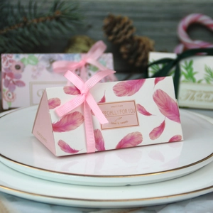 Scatola di caramelle triangolare rosa con piume e nastro per bomboniere di nozze