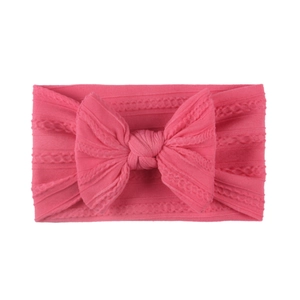 Detailed knit texture of soft nylon baby headband with a large pink jacquard bow