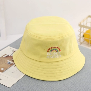 Close-up of rainbow embroidery and text on a yellow cotton kids bucket hat detail