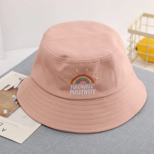 Close-up of rainbow embroidery and Radiate Positivity text on pink cotton sun hat