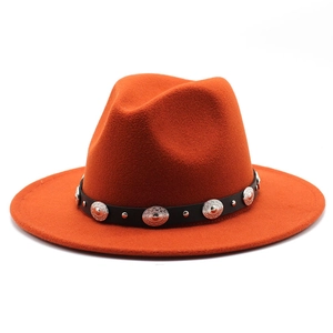 Detail of burnt orange fedora hat featuring black leather band and silver concho studs