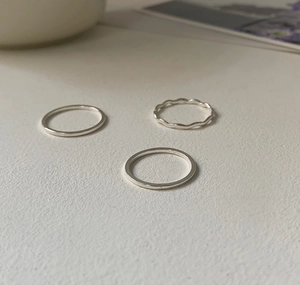 Detailed view of minimalist 925 sterling silver three-piece ring set with wavy texture
