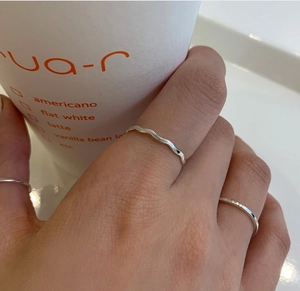 Close-up of minimalist 925 sterling silver square line rings worn by a model
