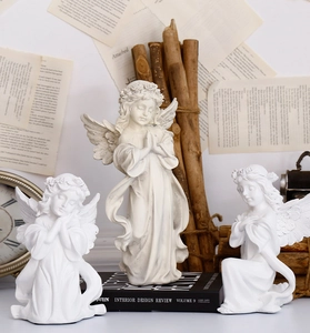 Detailed view of three white resin cherub angel figurines with floral crowns and wings