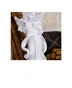 Macro view of white resin angel sculpture showing intricate wing details and prayer pose