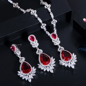 Macro detail of bridal jewelry set with red pear-cut gems and sparkling marquise crystals