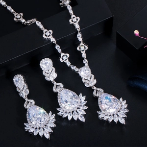 Detailed view of silver bridal jewelry set with pear-cut crystals on black display