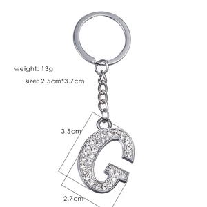 Detailed view of silver letter G keychain with sparkling rhinestones and metal ring