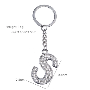Macro detail of silver-tone letter S keychain with sparkling rhinestones and measurements