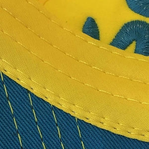 Detailed macro view of the two-tone contrast stitching and embroidery on the baseball cap