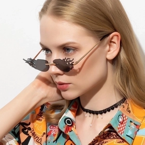 Trendy rimless flame-shaped sunglasses with dark grey lenses and golden metal temples