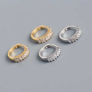 Detailed view of gold and silver S925 sterling silver earrings with baguette zircon stones