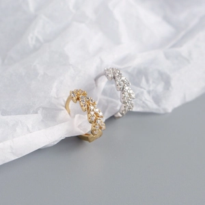 Macro detail of leaf-shaped S925 sterling silver hoop earrings with sparkling zircons