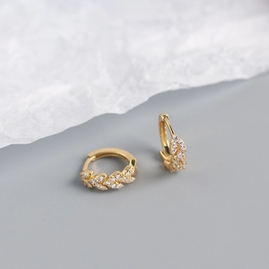 Detailed close-up of S925 silver gold-plated leaf earrings with sparkling cubic zirconia