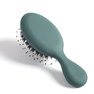 Detail of ergonomic dark green matte hairbrush with boar bristles and nylon pins