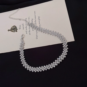 Sparkling silver choker necklace with multiple rows of rhinestones on a dark surface