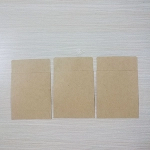 Three small blank translucent vellum paper envelopes arranged on a light wood background