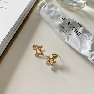 Detailed view of S925 silver pearl stud earrings with irregular gold texture
