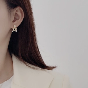 Macro view of gold S925 sterling silver irregular pearl earrings on model ear