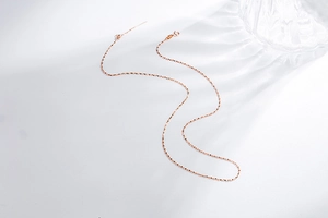 Close-up of rose gold adjustable S925 silver chain with spring clasp and sparkling texture