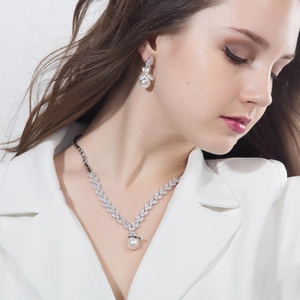 Elegant bridal jewelry set with pearl necklace and earrings on a model in wedding dress
