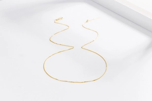 Detail of elegant gold box chain necklace with adjustable needle pin for beads