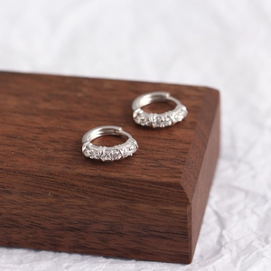 Elegant S925 sterling silver hoop earrings with sparkling cubic zirconia on wood
