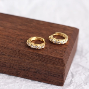 Detailed view of gold plated sterling silver hoop earrings with five set zircons