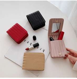 Detail of four colorful leather lipstick pouches with built-in mirror and striped texture