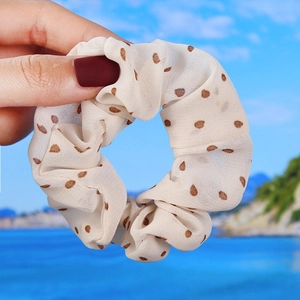 Close-up of cream chiffon hair scrunchie with coffee-colored polka dots pattern