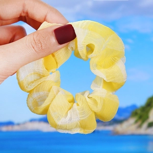 Close-up of yellow and white checkered organza scrunchie showing translucent fabric texture