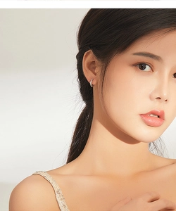 Detail of a minimalist silver infinity twisted hoop earring worn by a model in profile