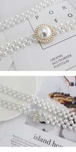 Détail d'une chaîne de taille à trois rangs de perles avec boucle en strass et abeille