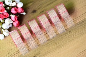 Lace eyelid tape rolls in pink dispensers featuring olive and crescent shapes